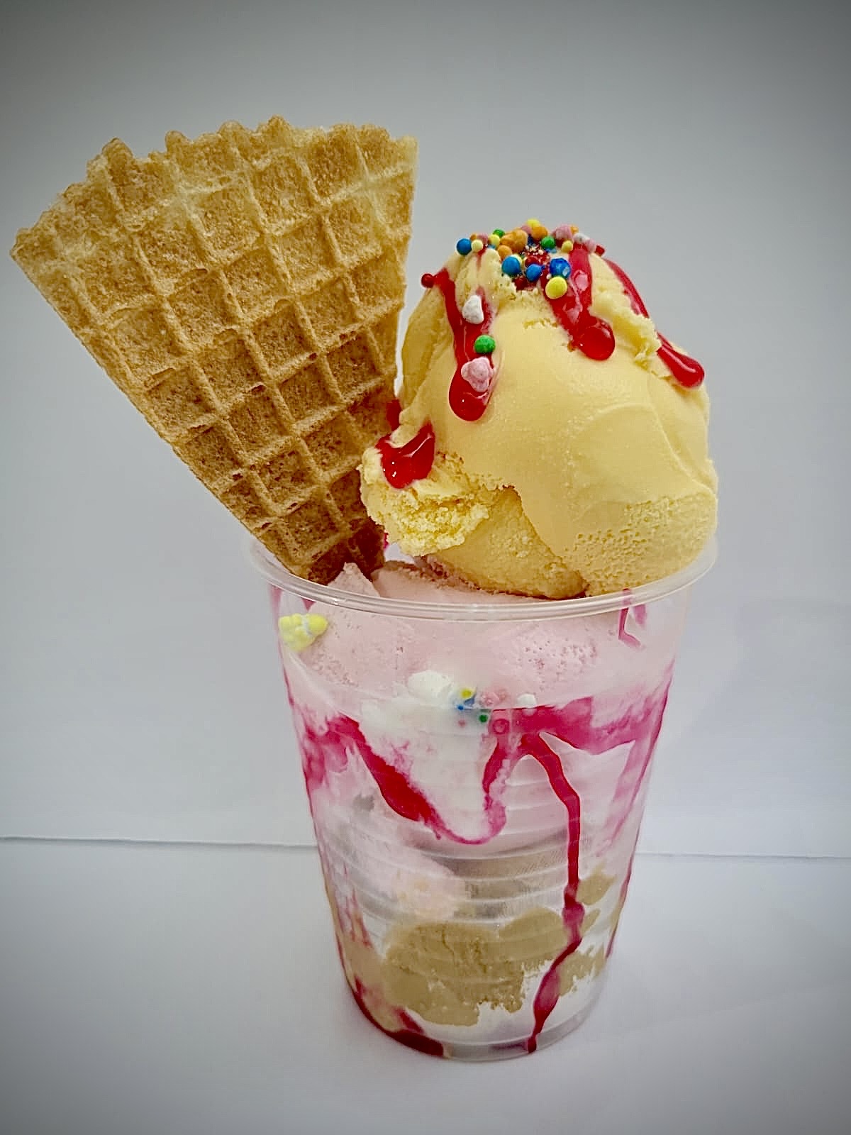 Vaso de helado de tres sabores con toppings